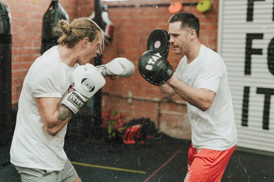 Two athletes working boxing pads