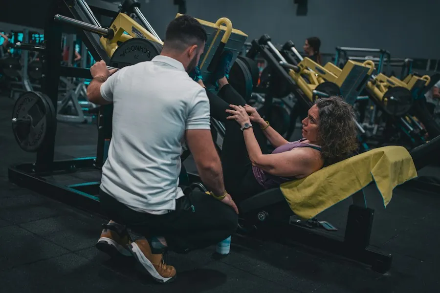 Coach spotting a member on a gym machine